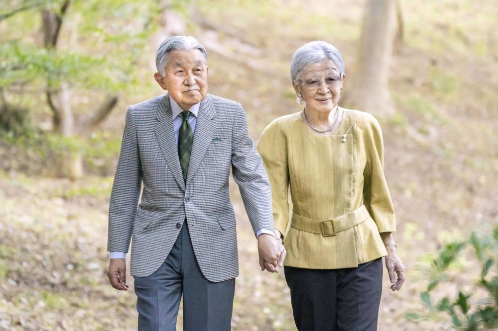 Empress Emerita Michiko, who turned 89 on Friday, walks with her husband, Emperor Emeritus Akihito, at their residence in Tokyo on Oct. 6.