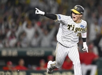 The Tigers' Seiya Kinami reacts after hitting a sayonara single against the Carp in Game 2 of the Central League Climax Series at Koshien Stadium in Nishinomiya, Hyogo Prefecture on Thursday. | KYODO