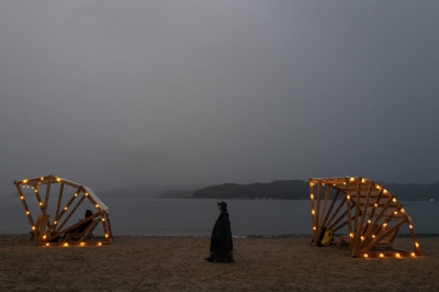 A festivalgoer walks along the water near Kyotophonie’s Beach Stage. Despite rain on the second day of the festival, attendees and musicians maintained a lively atmosphere until the nighttime finale. 