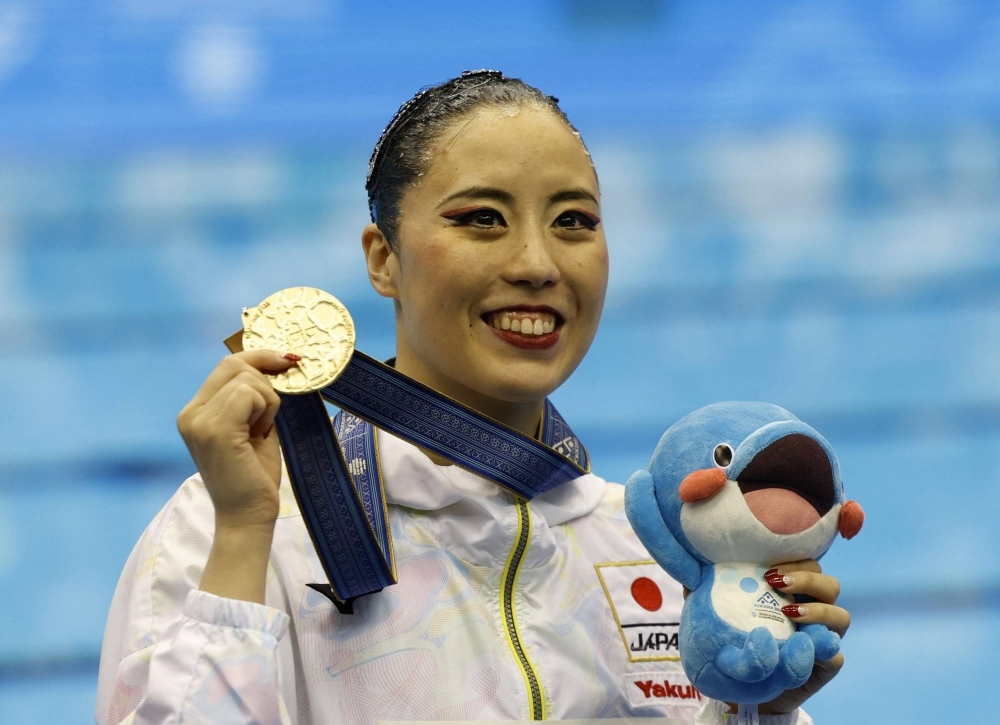 Artistic swimmer Yukiko Inui celebrates on the podium after winning the women's solo free final at the World Aquatics Championships in Fukuoka on July 19.
