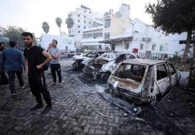 People inspect the area of a hospital where hundreds of Palestinians were killed in a blast that Israeli and Palestinian officials blamed on each other, and where Palestinians who fled their homes were sheltering amid the ongoing conflict with Israel, in Gaza City, the Gaza Strip, on Wednesday.