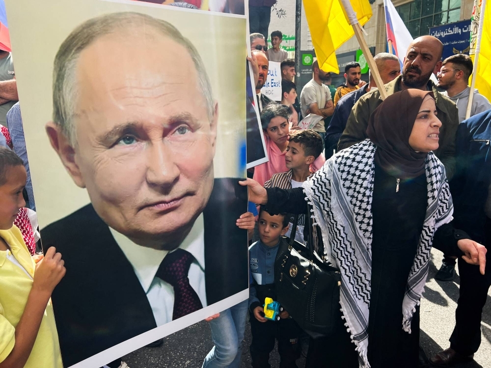 Palestinians hold a picture of Russian President Vladimir Putin during a protest in support of the people of Gaza, as the conflict between Israel and Hamas continues, in Hebron, in the Israeli-occupied West Bank, on Friday.
