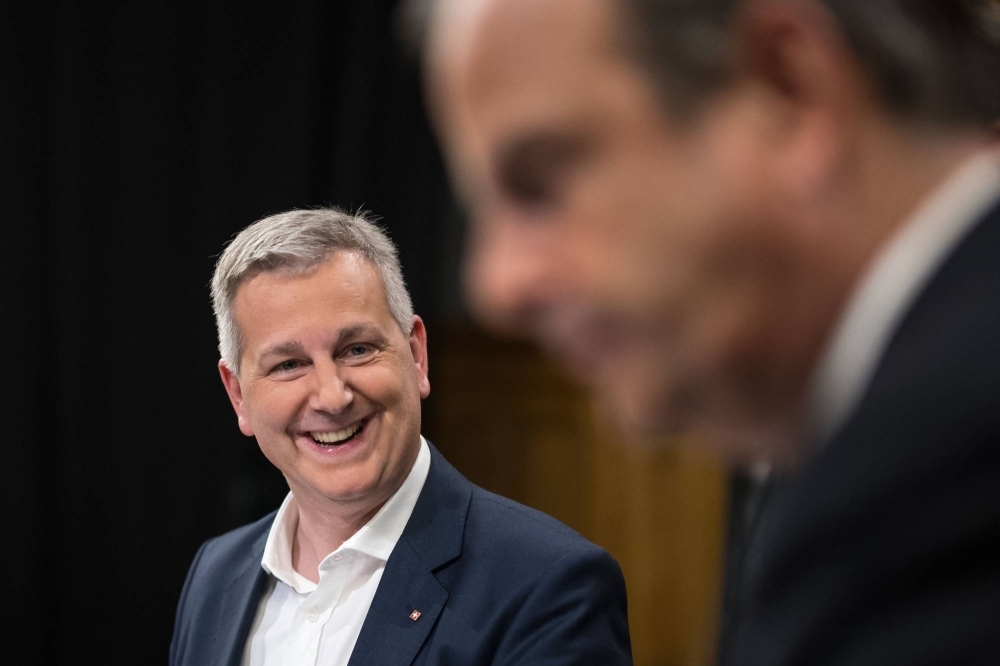 Swiss People's Party (SVP) leader Marco Chiesa (left) smiles next to the president of The Center (Die Mitte) Swiss political party Gerhard Pfister prior to a TV interview in Bern on Sunday.