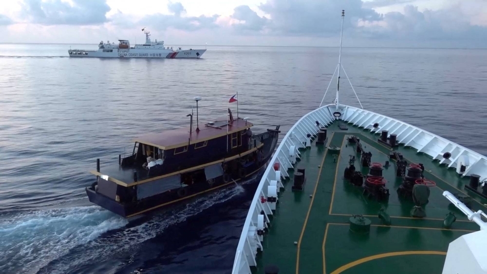 A Philippine-flagged boat is blocked by a China Coast Guard vessel during an incident that resulted in a collision between the two ships in the disputed waters of the South China Sea in this screen shot taken from video on Sunday.