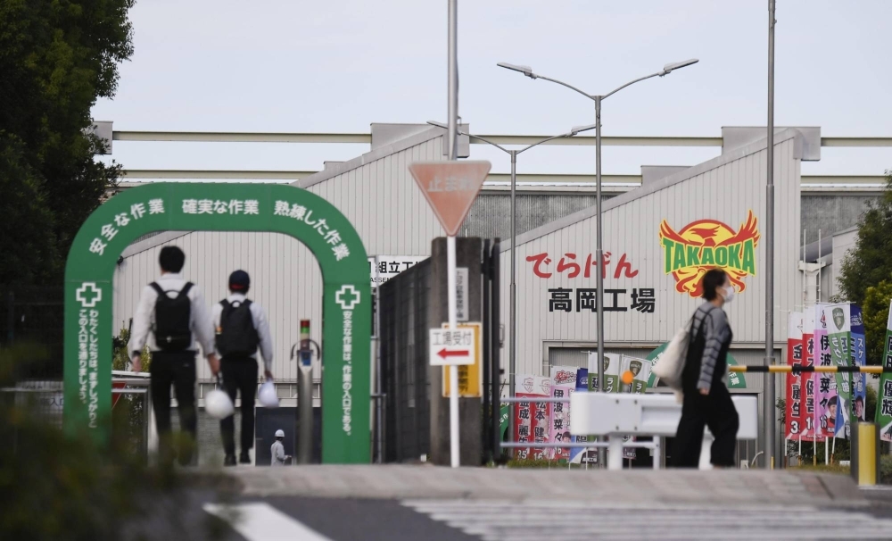 Workers walk to Toyota's Takaoka Plant in Toyota, Aichi Prefecture, on Monday as it restarted its production line.