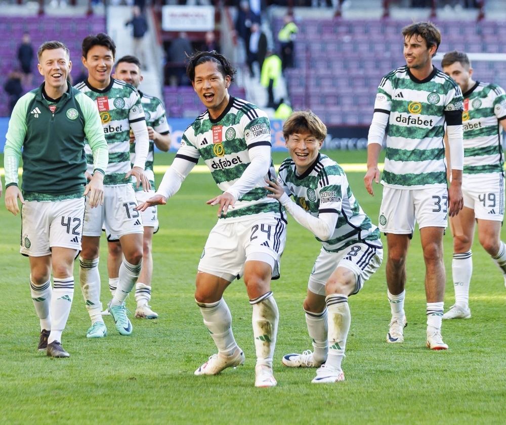 Japanese players Tomoki Iwata (center left) and Kyogo Furuhashi (center right) celebrate Celtic's win against Hearts in a Scottish Premiership football match at Tynecastle Park in Edinburgh on Sunday.