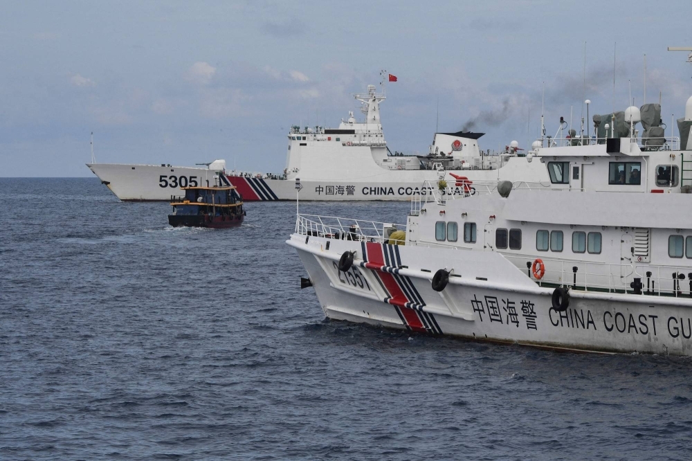 China Coast Guard ships corral a Philippine civilian boat chartered by the Philippine Navy to deliver supplies to the grounded BRP Sierra Madre vessel in the disputed South China Sea in August.