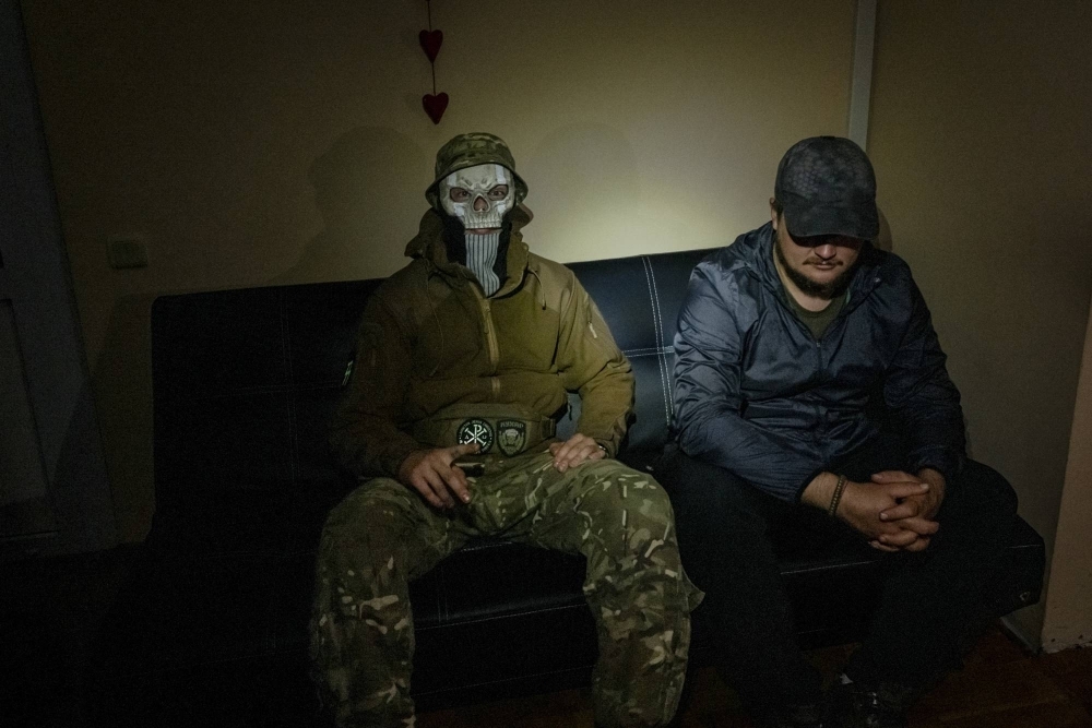 Ukrainian commandos known as Kukhar (left), 23, and Askold, 38, who conceal their identities, in a bare office used as a safe house in Kyiv on Oct. 5. Inside the commando raids unnerving Russia in Crimea; the lightning assaults are part of a larger campaign using drones and missiles to degrade Russian forces and demoralize the public.