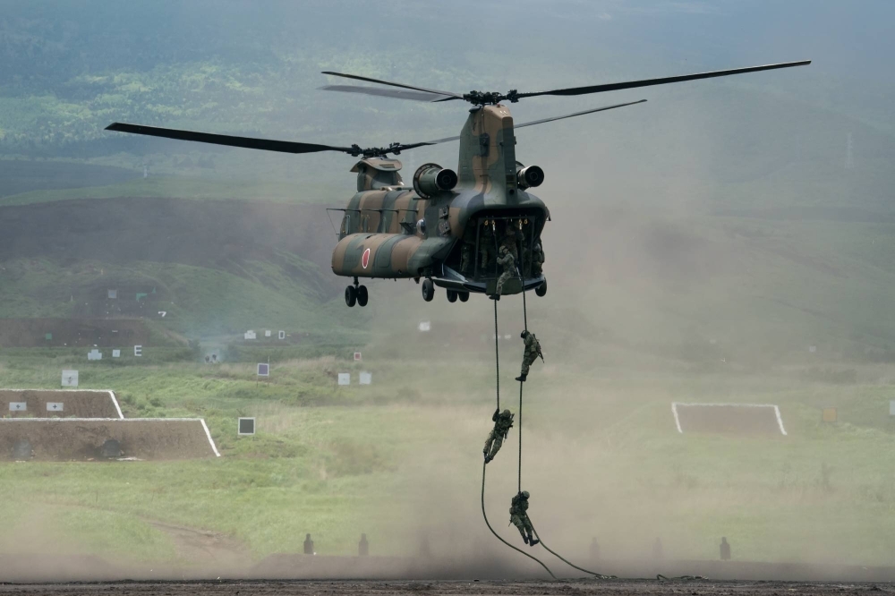 Members of the Ground Self-Defense Force disembark from a CH-47 Chinook helicopter during a live fire exercise in Gotemba, Shizuoka Prefecture, in May 2022.