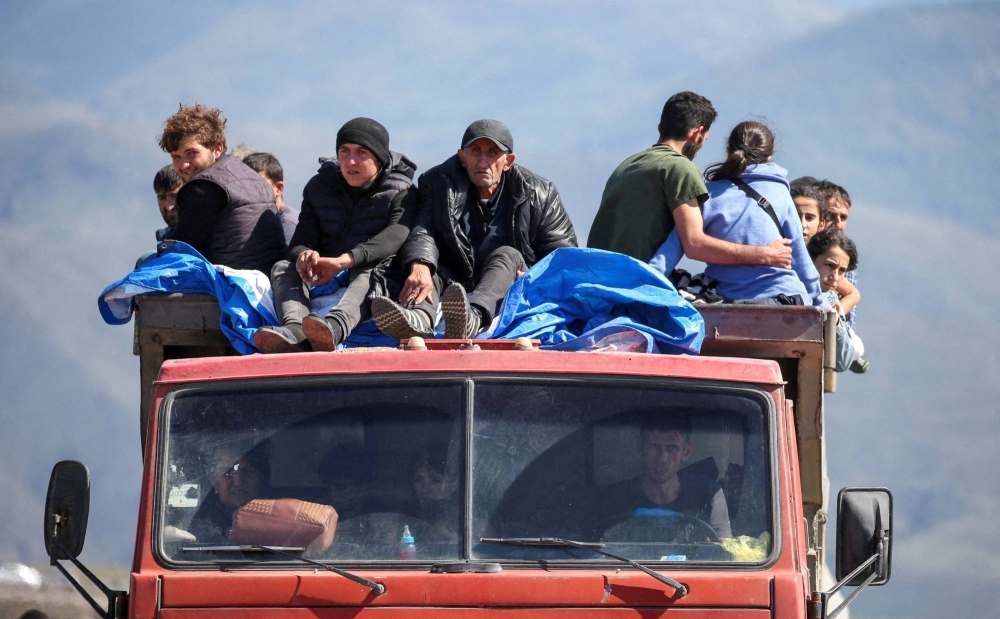 Refugees from Nagorno-Karabakh region ride in a truck upon their arrival at the border village of Kornidzor, Armenia, on Sept. 27