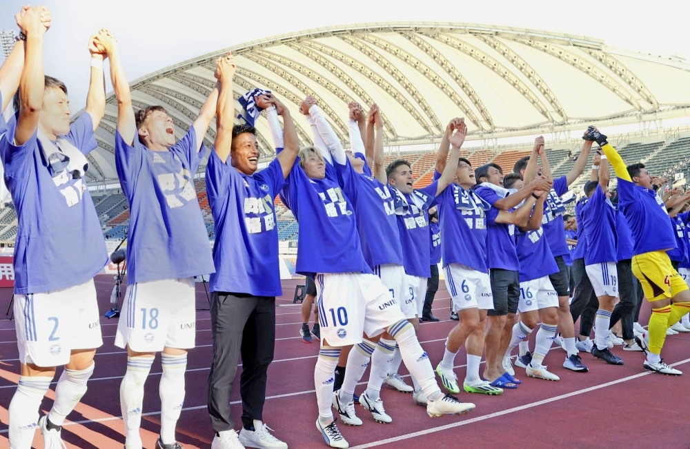Machida Zelvia players celebrate their promotion to the J1, in Kumamoto on Sunday.
