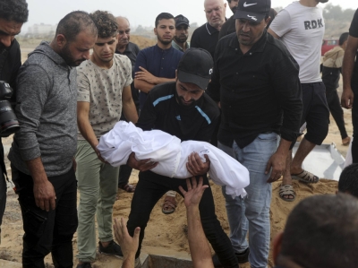 Mourners bury children and their father, who were killed during Israeli airstrikes on their home, in Khan Younis in the southern Gaza Strip, on Monday