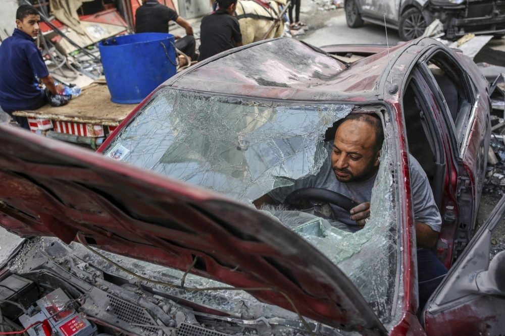A man tries to start his car after Israeli airstrikes at the Nuseirat Market in the Gaza Strip on Monday.