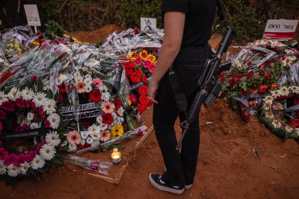 Flowers are left on the graves of Sgt. Yam Goldstein and her father, Nadav, during their funeral in Shefayim, a kibbutz in central Israel, on Monday.