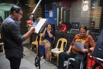 Voice actors record their parts for a radio drama at a radio station studio in Manila.