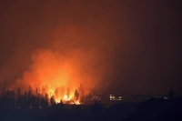 The McDougall Creek wildfire burns next to houses in the Okanagan community of West Kelowna, British Columbia, on Aug. 19. | REUTERS