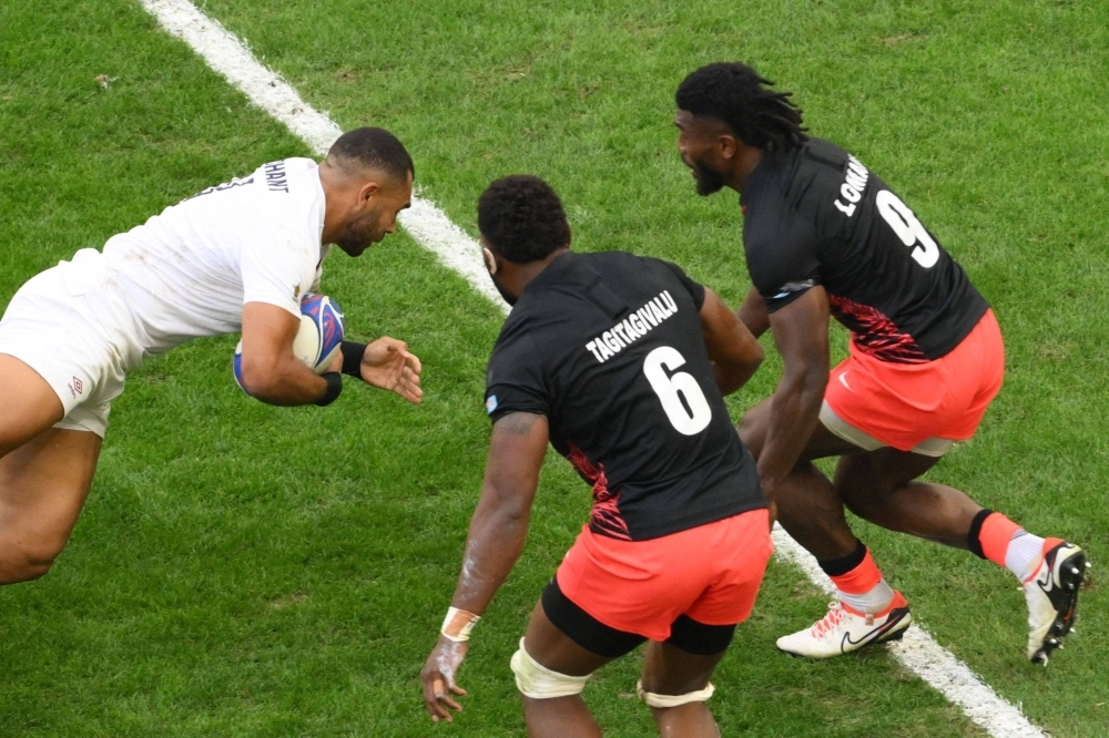 England's outside center Joe Marchant (left) scores a try against Fiji during the quarterfinals of the Rugby World Cup in Marseille, France, on Oct. 15. 