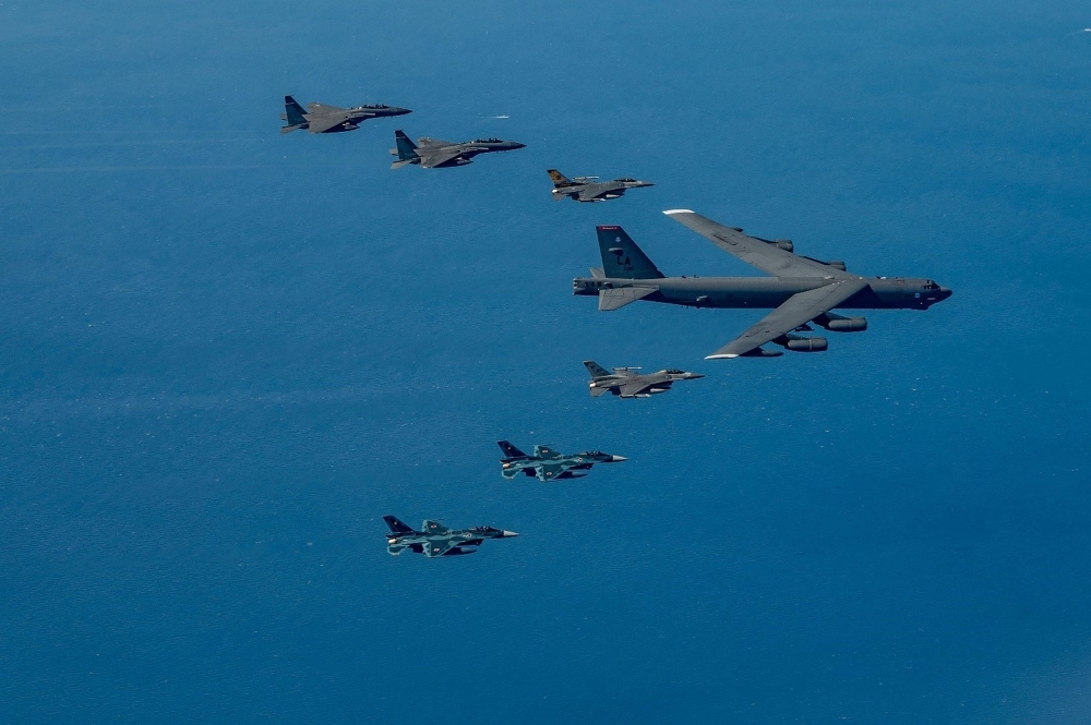 Two Air Self-Defense Force F-2 fighter jets (bottom) fly in formation with a U.S. Air Force B-52 bomber as part of a joint exercise with the United States and South Korea in airspace near Kyushu on Sunday.