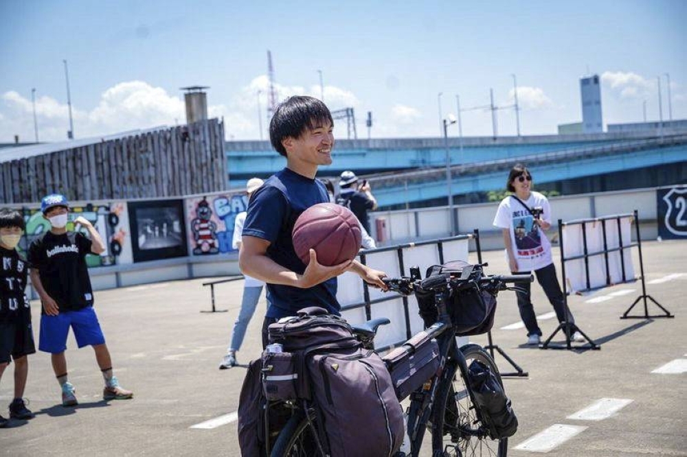 Takumi Hara participates in a basketball event in Fukuoka in May 2022 during his round-the-country cycling tour to raise awareness of mental health issues.
