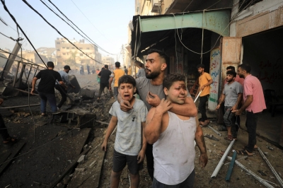 People react as Palestinians search for casualties at the site of an Israeli strike on a residential building in Gaza City, on Wednesday.