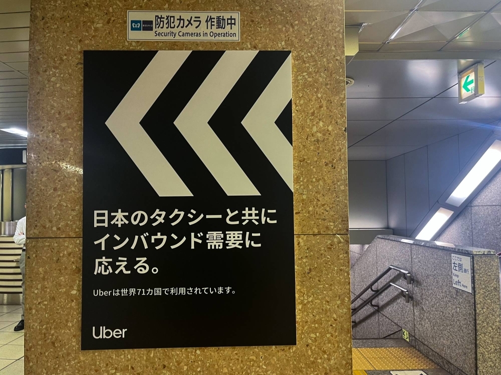 A poster for Uber displayed at a Tokyo subway station reads: "Meeting inbound demand together with Japan's taxis." It also notes that its service is used in 71 countries.