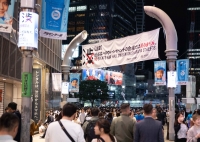 A banner at the entrance to Shibuya’s Center Street makes it clear this is no place for a party.  | TAIDGH BARON

