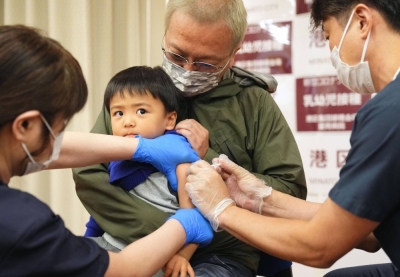Medical staff administer a COVID-19 vaccination in Tokyo's Minato Ward in October last year.