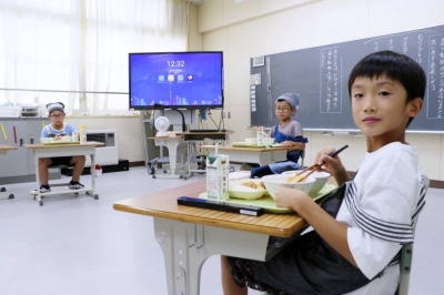 Three pupils in the third-grade class at Utashinai Gakuen eat school lunch on Sept. 6, in Utashinai, Hokkaido. The combined elementary and junior high school has just 70 students.