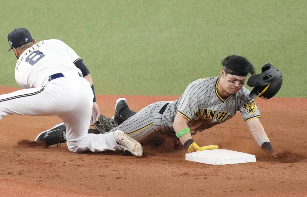Tigers third baseman Teruaki Sato steals second against the Buffaloes in the third inning during Game 1 of the Japan Series at Kyocera Dome Osaka on Saturday.