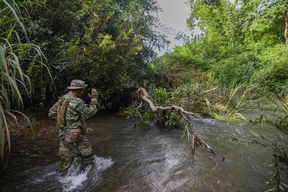 Kam Phon, a Ministry of Environment ranger, directs a river crossing during a patrol in Cambodia’s Virachey National Park.