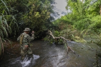 Kam Phon, a Ministry of Environment ranger, directs a river crossing during a patrol in Cambodia’s Virachey National Park. | Anton L. Delgado
