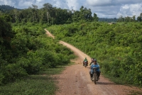 Mark Thayre, deputy head of mission at the British Embassy in Phnom Penh, exits Cambodia’s Virachey National Park on the back of a motorbike with a community ranger. | Anton L. Delgado
