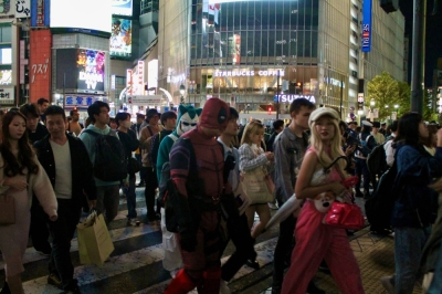 People visit Tokyo’s Shibuya Ward on Saturday, including a handful of costumed revelers gathering in the trendy area to celebrate the weekend before Halloween.