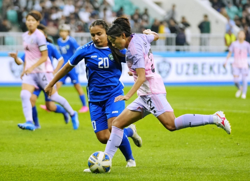 Nadeshiko Japan's Remina Chiba (right) scores in the first half of a women's Olympic soccer qualifying match against Uzbekistan at Bunyodkor Stadium in Tashkent, Uzbekistan, on Sunday.