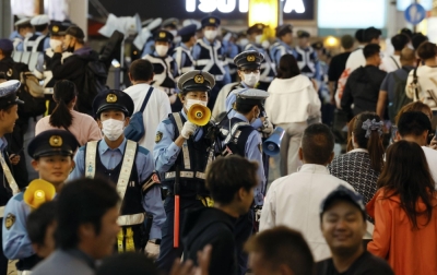 Police watch over the Dotonbori area in Osaka on Oct. 20 as Tigers fans flocked to the area to celebrate the team's advance to the Japan Series.