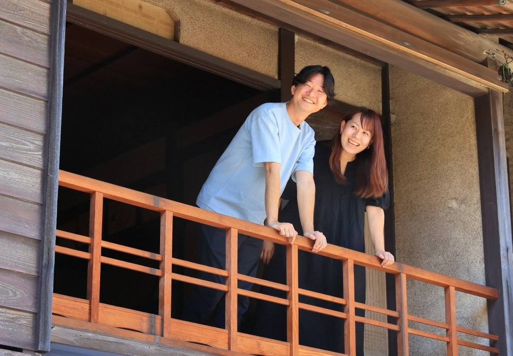 Ryo and Kaho Nagata greet a regular customer from the second floor of their cafe in Fukuyama, Hiroshima Prefecture.