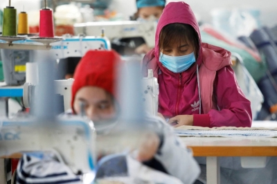 Laborers work at a private garment factory in Hanoi in 2021.