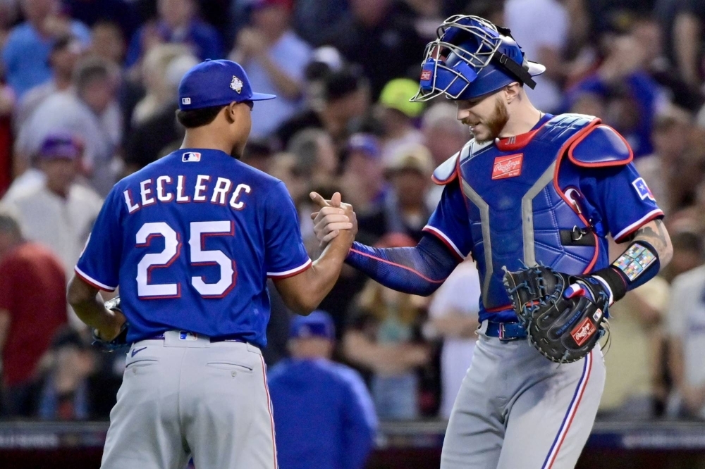 Texas Rangers relief pitcher Jose Leclerc (left) and catcher Jonah Heim celebrate after defeating the Arizona Diamondbacks in Game 3 of the World Series at Chase Field in Phoenix on Monday.