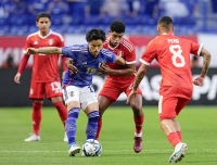 Japan's Reo Hatate vies for the ball in the first half of an international football friendly against Peru on June 20 at Panasonic Stadium in Suita, Osaka Prefecture. | Kyodo

