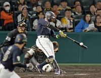 Buffaloes third baseman Yuma Mune hits a two-run double against the Tigers in Game 3 of the Japan Series at Koshien Stadium in Nishinomiya, Hyogo Prefecture, on Tuesday. | KYODO