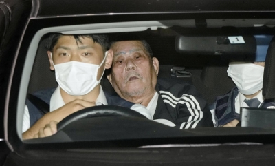 Tsuneo Suzuki (center), the suspect arrested after a police raid of a post office in Warabi, Saitama Prefecture, on Tuesday, is taken to a police station in the prefecture.