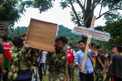 People carry a coffin as a mass funeral takes place to bury victims of a military strike on a camp for displaced people near the northern Myanmar town of Laiza on Oct. 10.