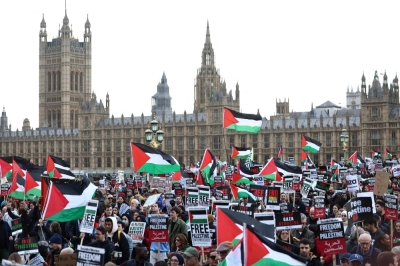 Protesters wave Palestinian flags as they walk over Westminster Bridge near the Houses of Parliament in London on Saturday. 

