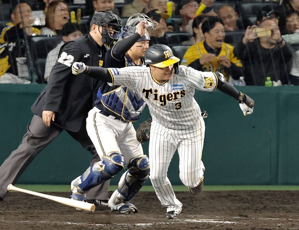 The Tigers' Yusuke Oyama hits a walk-off single to lift his team to a win over the Buffaloes in Game 4 of the Japan Series at Koshien Stadium in Nishinomiya, Hyogo Prefecture, on Wednesday night. 