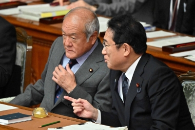 Prime Minister Fumio Kishida chats with Finance Minister Shunichi Suzuki (left) in a parliamentary session in October.