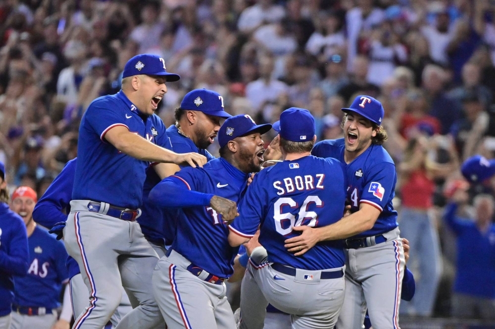 Texas Rangers players storm the field after defeating the Arizona Diamondbacks to win the World Series in Game 5 on Wednesday in Phoenix. 