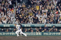 Tigers outfielder Koji Chikamoto races home to score the winning run in Hanshin's Game 4 win on Wednesday at Koshien Stadium.  | Kyodo 