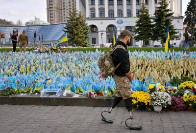 A serviceman, wearing prosthetic legs, walks past Ukrainian flags symbolizing fallen soldiers on the Independence Square in Kyiv, on Oct. 30.