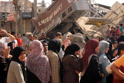 People queue for bread in front of a bakery that was partially destroyed in an Israeli strike, in the Nuseirat refugee camp in the central Gaza Strip, on Thursday.
