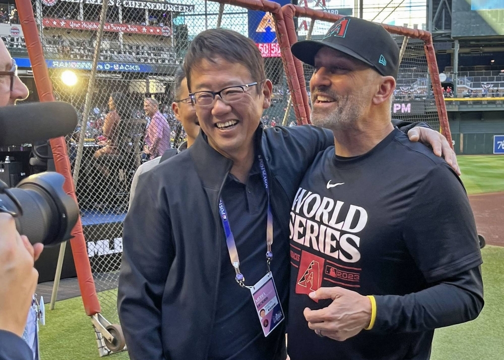 Former Yakult Swallows catcher Atsuya Furuta (left) reunites with former teammate and current Arizona Diamondbacks manager Torey Lovullo ahead of Game 3 of the MLB World Series at Chase Field in Phoenix on Monday.